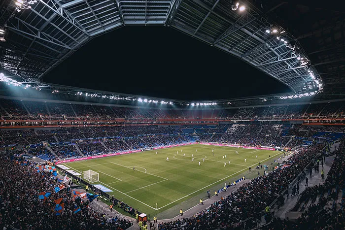Football stadium filled with fans enjoying a night match, capturing the essence of "me time" activities.