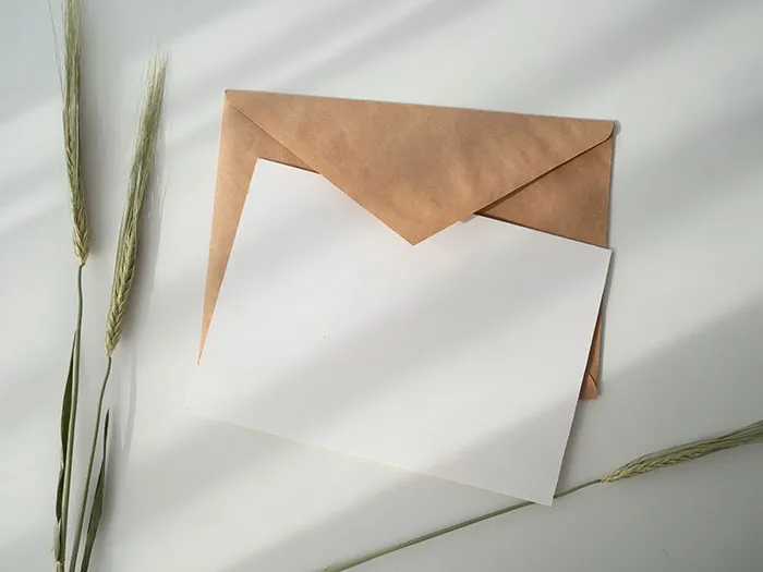 Brown envelope with a white card on a sunlit surface, symbolizing "me time" activities or letter writing.