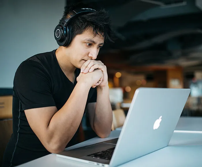 Person wearing headphones, focused on a laptop, enjoying some me time.