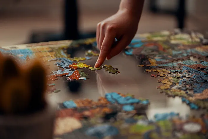 Person enjoying some me time by working on a complex jigsaw puzzle.