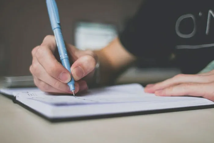 Person writing stuff in notepad 