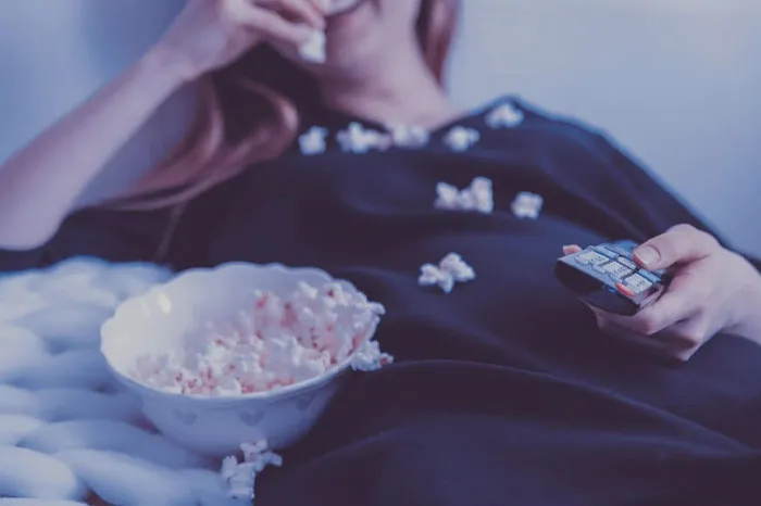 Person in bed eating popcorns 