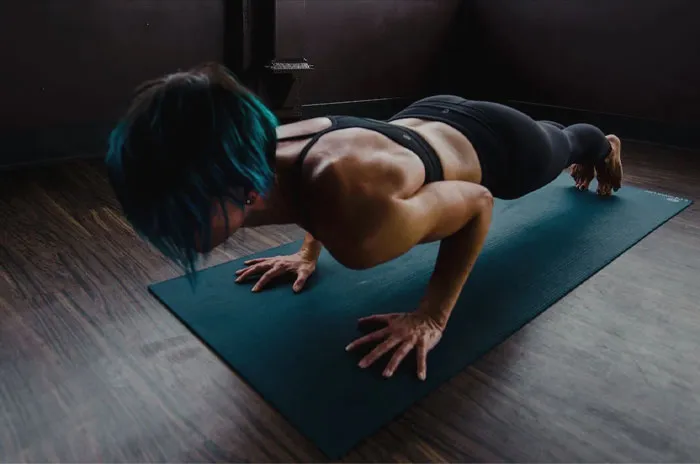 Woman doing pushups on a yoga mat 