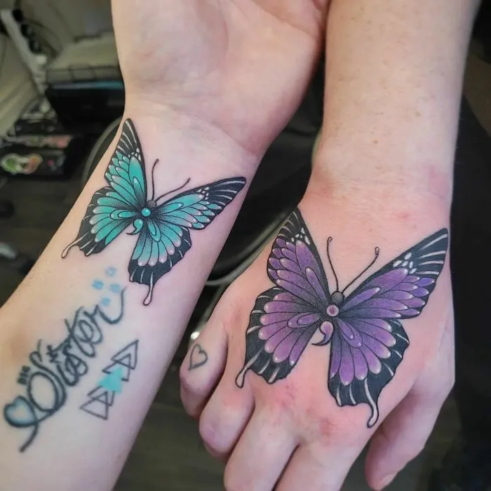 Butterfly best friend tattoos on wrists, featuring a blue and purple design symbolizing friendship.