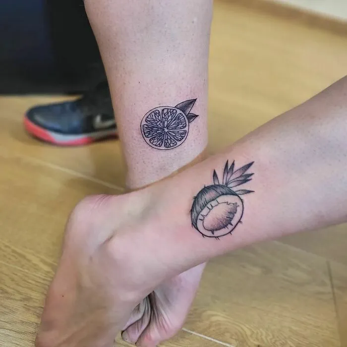 Matching citrus and coconut tattoos on ankles, symbolizing best friend tattoos for commemorating friendship.