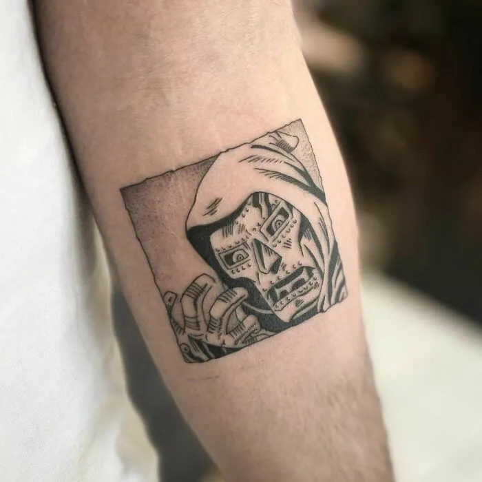 Marvel tattoo featuring detailed black and gray illustration on forearm.