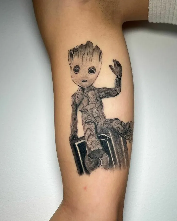 Groot tattoo on arm, showcasing detailed Marvel artwork.