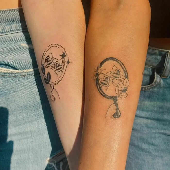 Matching best friend tattoos on forearms, symbolizing friendship with heart and leaf designs.