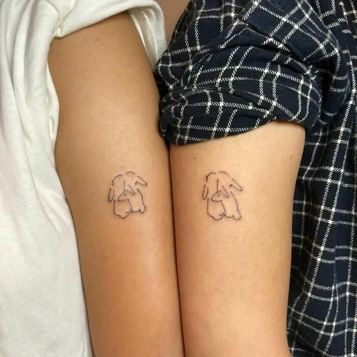 Minimalist tattoos of rabbits on two arms, showcasing simple and aesthetically pleasing designs.