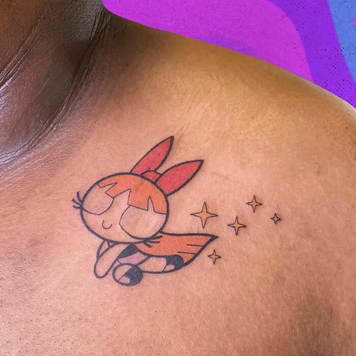 Colorful cartoon tattoo with a character inspired by classic animated shows on shoulder, featuring stars beside it.