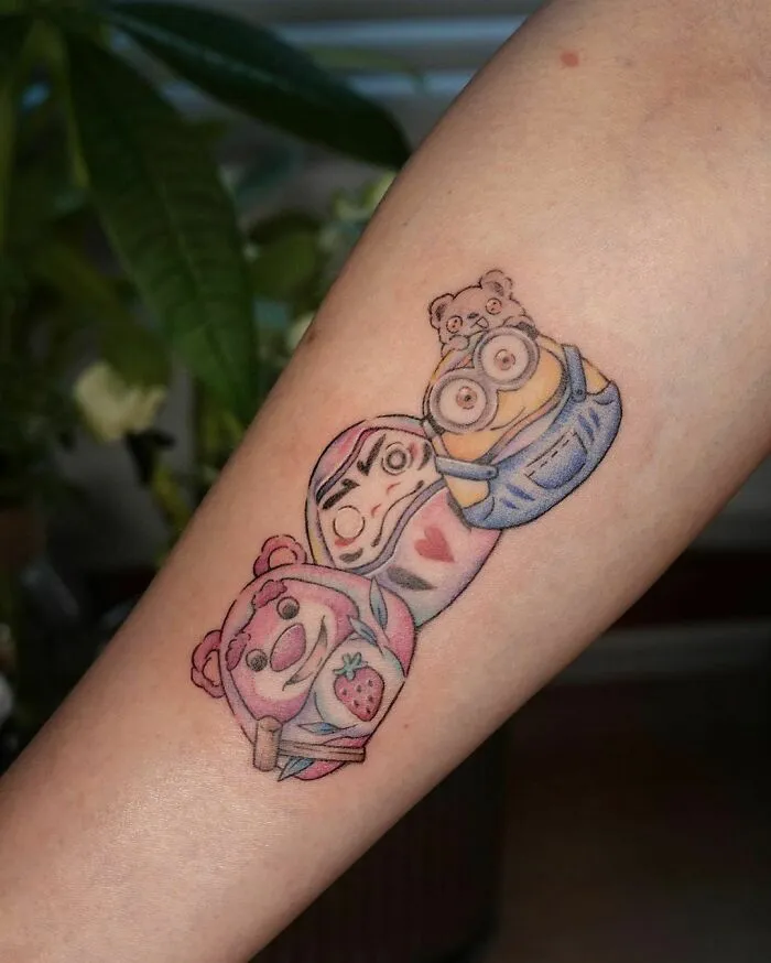 Cartoon tattoo featuring characters from animated shows on forearm.