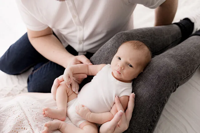 A photograph of a newborn with their parents