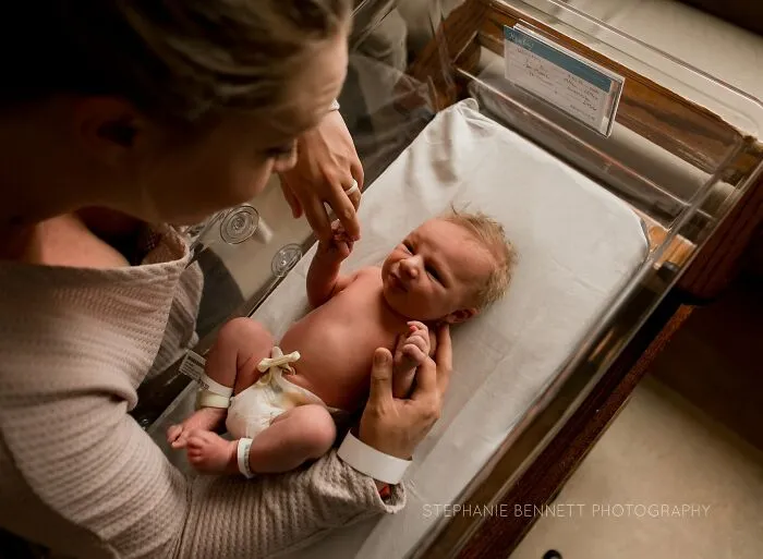 A photograph of a newborn with their family