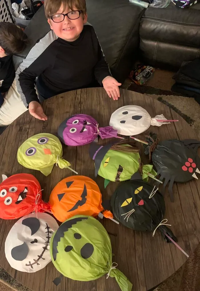 Mi hijo y yo hicimos "paletas" de Halloween para su clase mañana. 2 platos con algunas cosas de caramelo, palos luminosos como el palito, luego papel de seda y cartulina como decoración
