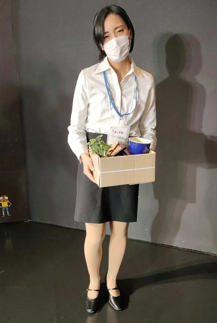Person in a white shirt and mask holding a box, representing a mundane Halloween costume concept.
