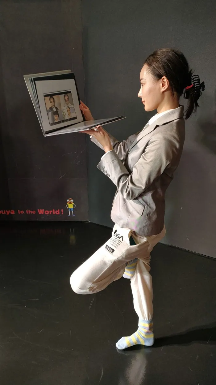 A woman in a suit and socks poses as a video conference call, capturing the idea of mundane Halloween costumes.