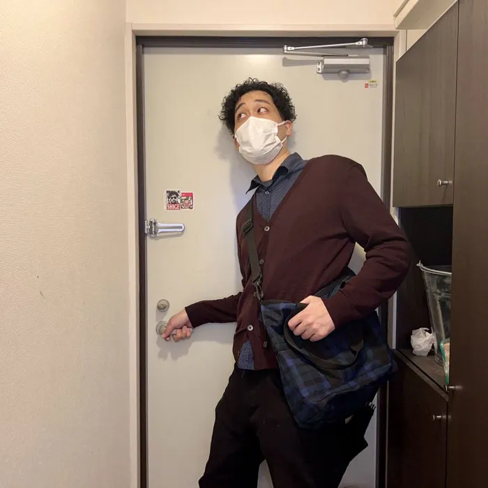 Person at door in mask with bag, wearing mundane Halloween costume for this year's funny theme.