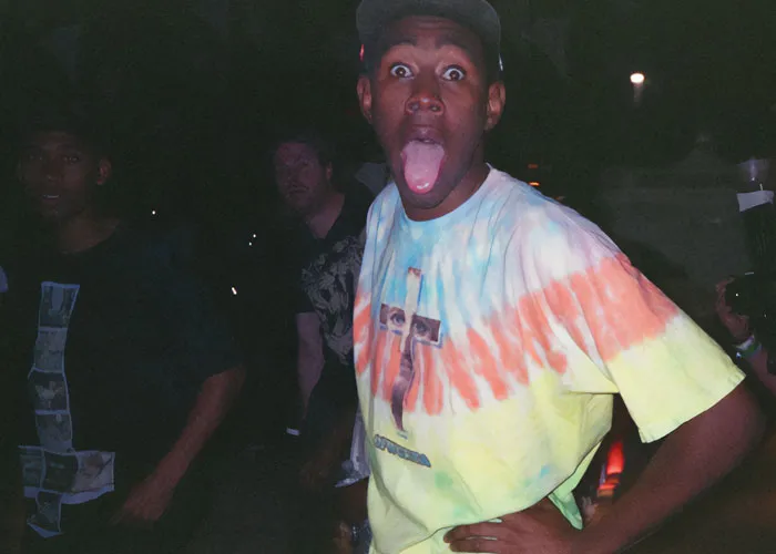 Young man wearing a tie-dye shirt making a funny face, capturing a moment before celebrities became very arrogant.