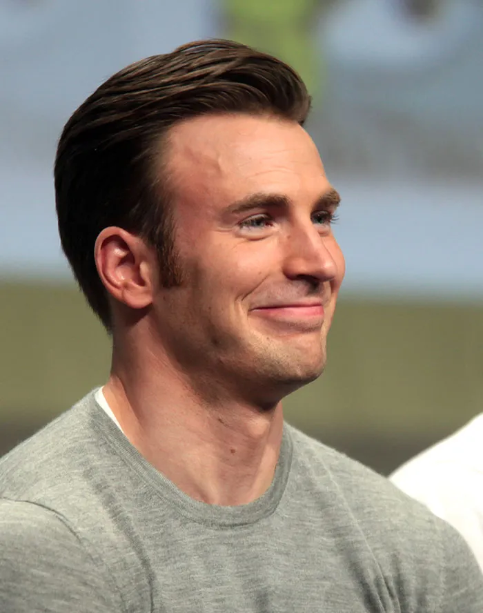 Smiling man in a gray sweater, revealing what celebrities were like before they became very arrogant and famous.