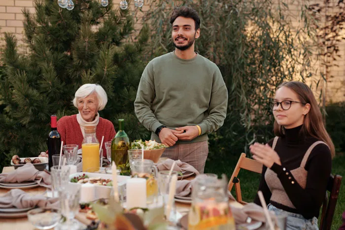 people around the table full of food and beverages