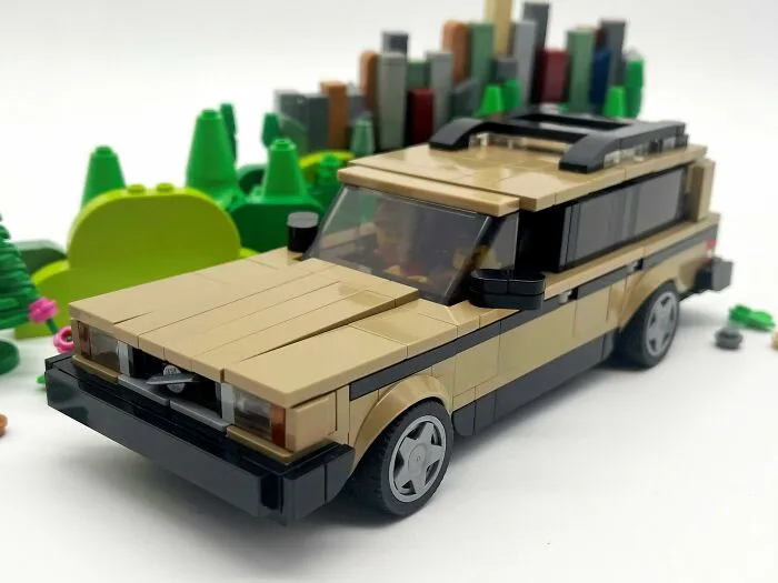 Beige LEGO car model with detailed features, surrounded by green LEGO trees, showcasing incredible LEGO builds art.