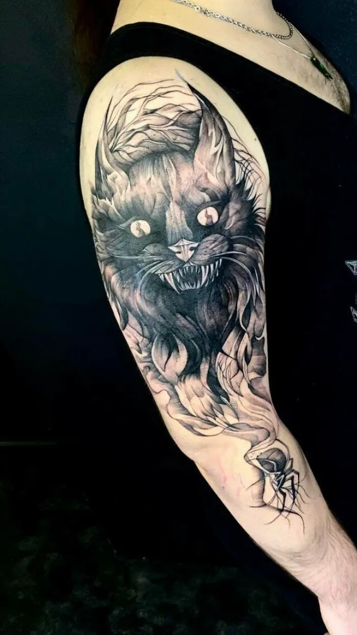 Psychedelic art tattoo featuring a detailed, surreal cat design on an arm.