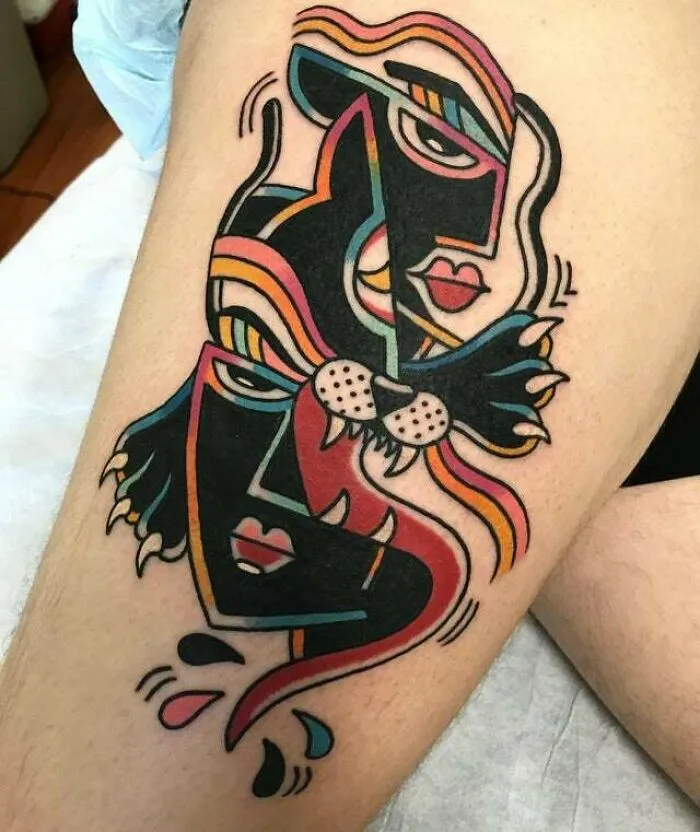 Trippy deconstructed panther faces tattoo on leg with bold, colorful geometric shapes.