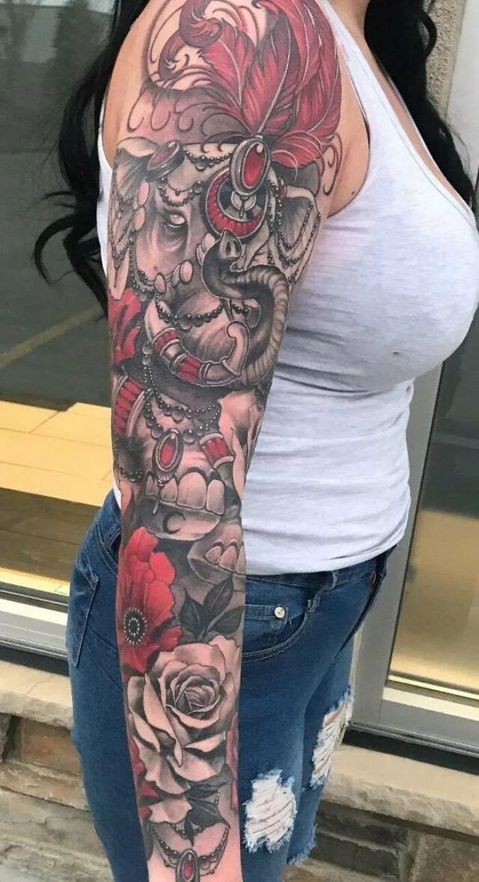 Trippy elephant tattoo with flowers covering a full arm sleeve.