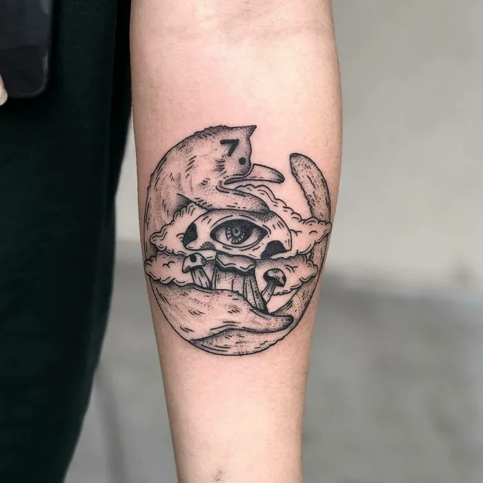 Psychedelic art tattoo featuring an eye, moon, and clouds on a forearm.