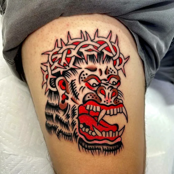 Trippy tattoo of a colorful screaming monkey on a leg.