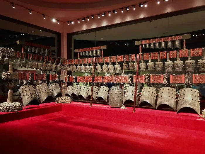 Historical artifact display of ancient ceremonial bells in a museum setting.