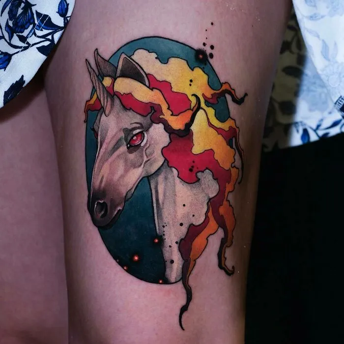 Unicorn leg tattoo with vibrant fire-like mane, showcasing a trippy tattoo design.