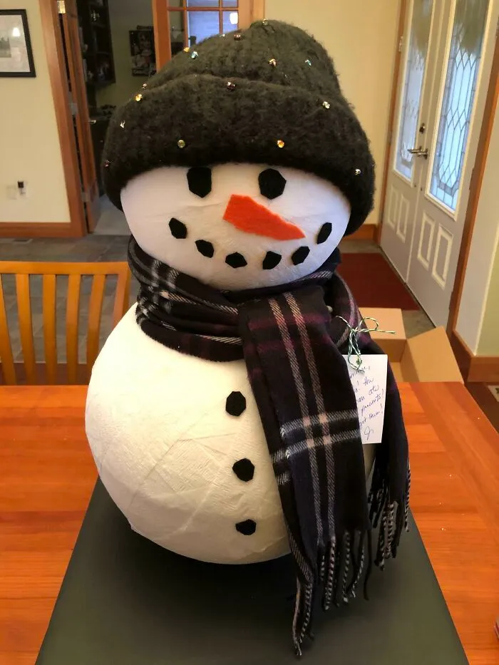 Un muñeco de nieve. La cabeza y el cuerpo son de telgopor hueco y sostienen los regalos. Le añadí una bufanda y un gorro para adornar 