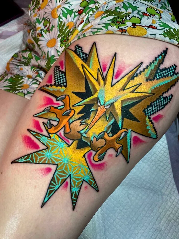 Colorful psychedelic tattoo with geometric patterns and vibrant starburst design on skin.