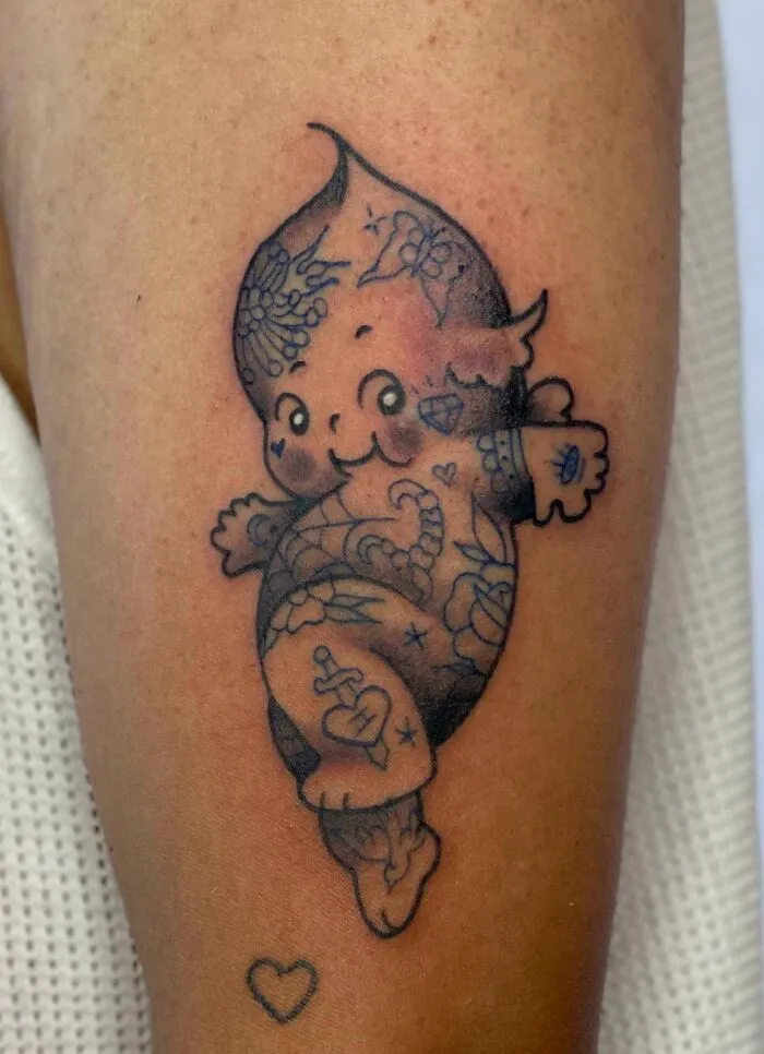 Trippy tattoo of a whimsical character with intricate patterns on a person's leg, showcasing psychedelic art.