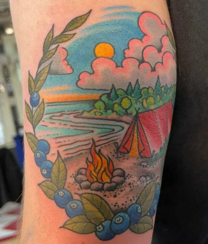 Colorful trippy tattoo featuring a campfire scene with blueberries, tent, and sunset by the beach.
