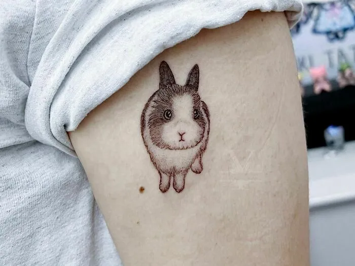 Detailed tattoo of a rabbit on an arm, symbolizing the bond between humans and their pets.