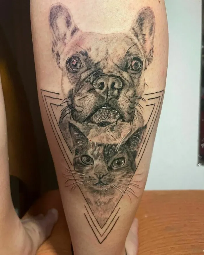 Pet tattoos featuring a realistic dog and cat design on a person's leg, symbolizing the human-pet bond.