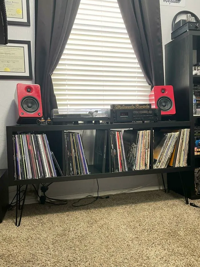IKEA furniture hack used as a stylish vinyl record storage with speakers and audio equipment on top.