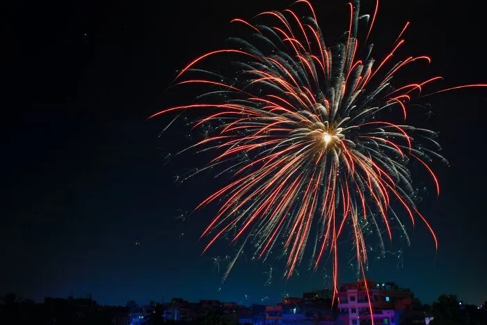 Fireworks lighting up the night sky over a cityscape on New Year’s Eve celebration.