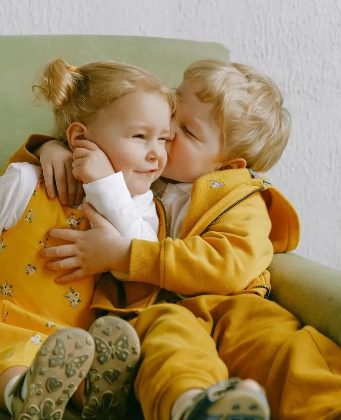 Children hugging on New Year’s Eve in matching yellow outfits, creating a joyful and playful scene.