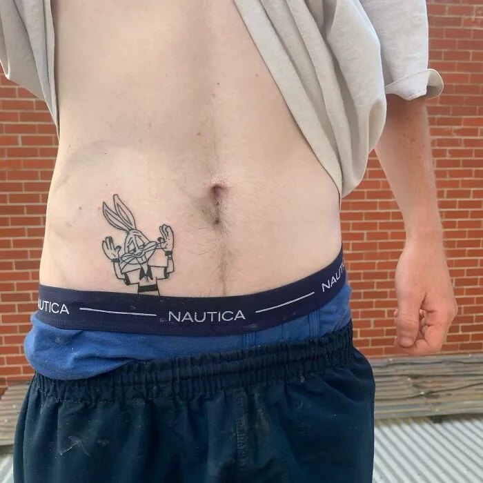 Cartoon tattoo of a famous animated rabbit character on a person's hip, inspired by classic animated shows.