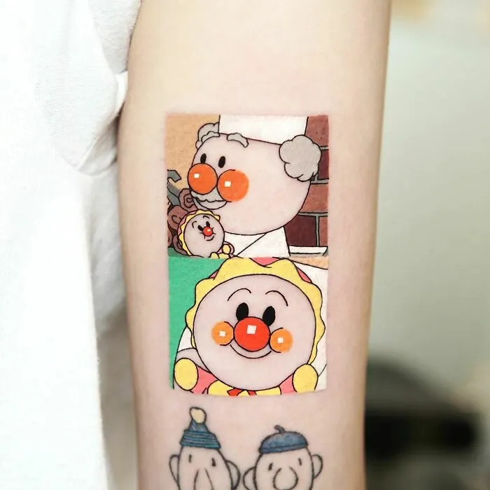 Cartoon tattoos featuring Anpanman characters on a person's forearm, evoking nostalgia.