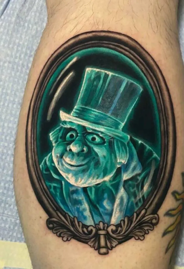 Cartoon tattoo of Phineas Hackenbush, Hitchhiking Ghost, in an ornate frame on a person's skin.