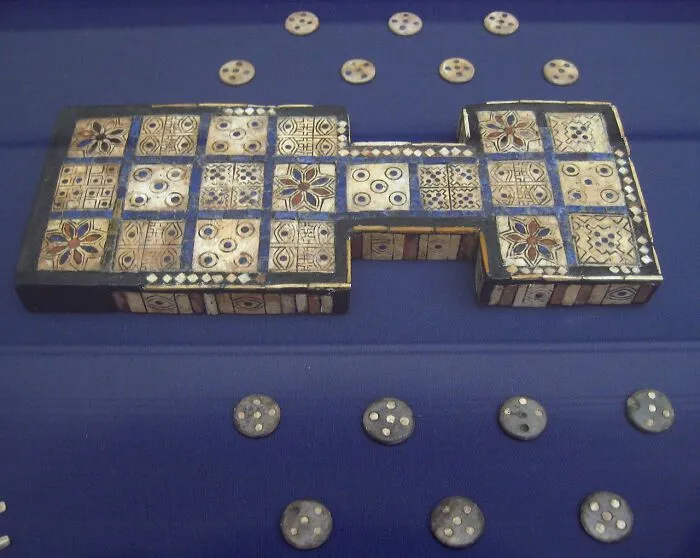 Ancient game board artifact with intricate designs and round pieces, showcasing historical information.