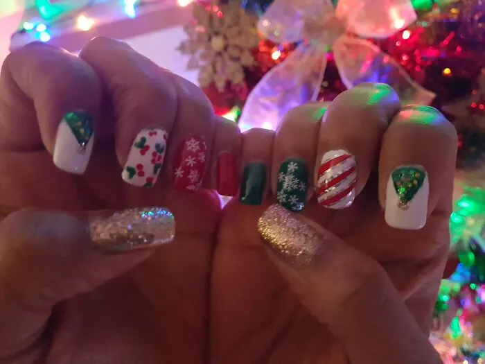 A colorful mix of Christmas nail art featuring festive trees, candy stripes, mistletoe, and snowflakes