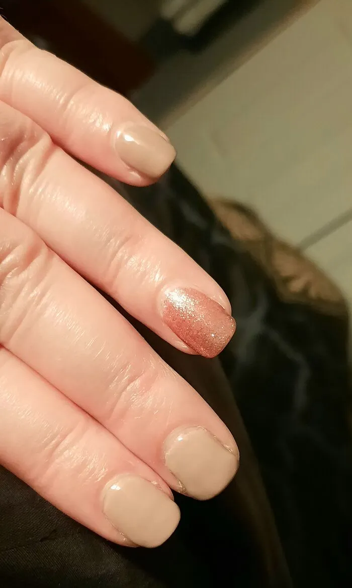 Simple winter nail art designs with neutral nude tones and a single shimmering pink glitter accent nail.