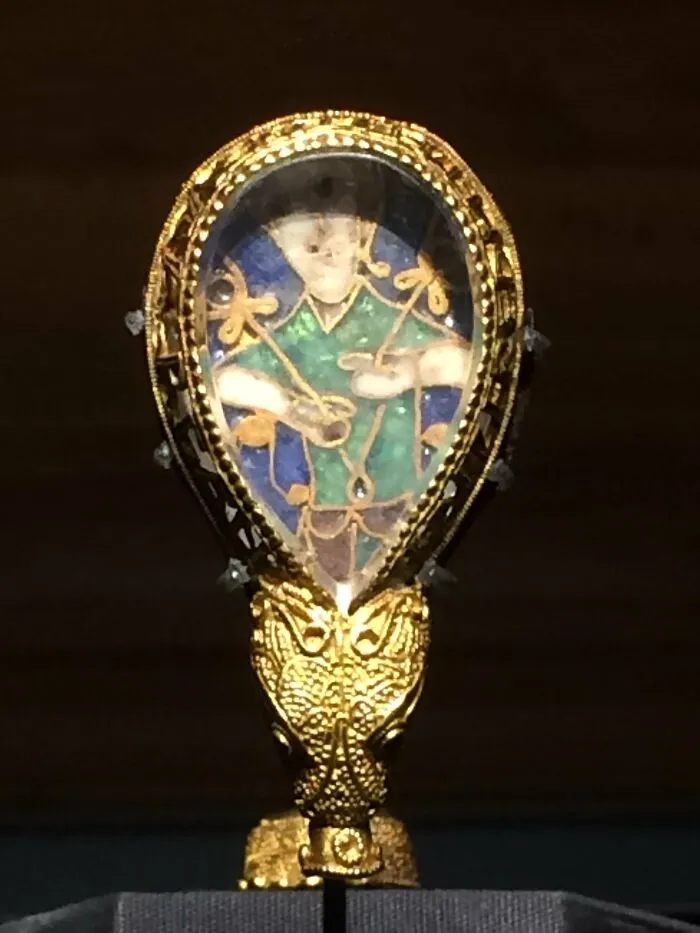 A well-known artifact featuring intricate gold detailing and an enamel depiction of a historical figure.