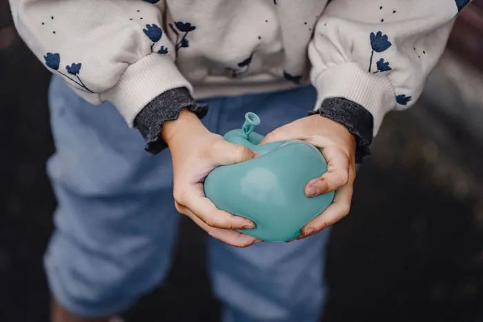kid trying pop a balloon