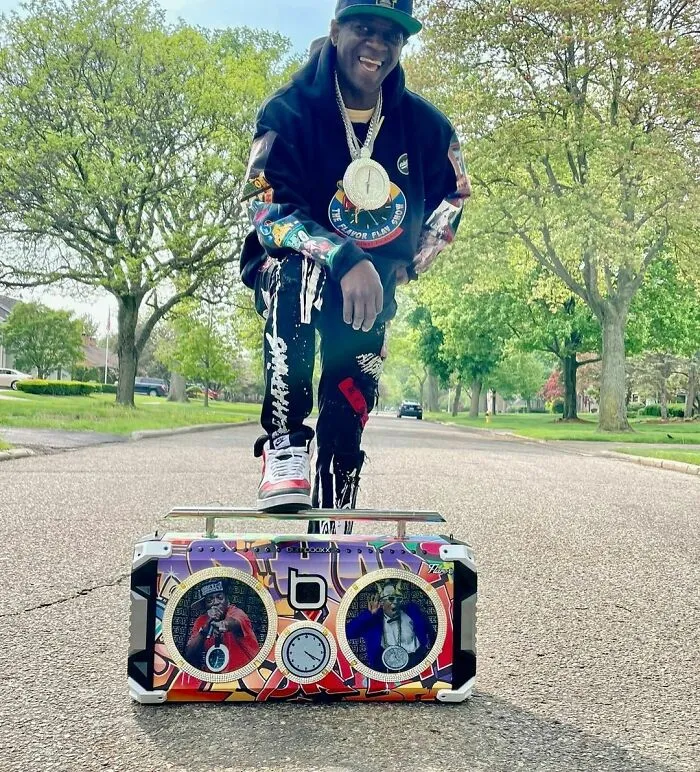 Hip hop artist posing outdoors with a colorful boombox, representing smartest celebrities known for their intelligence.